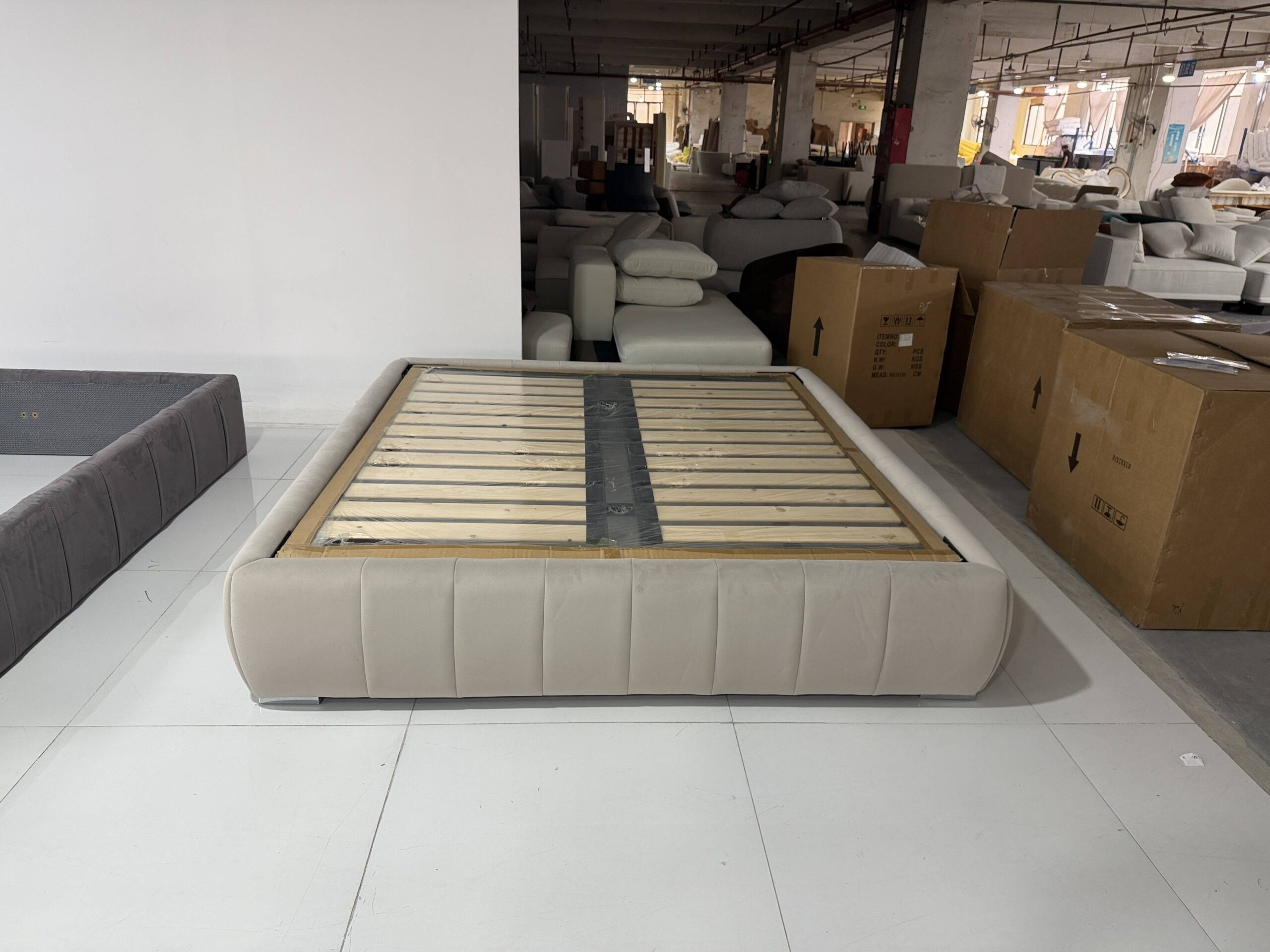Hotel bed being manufactured in Foshan factory production line showing headboard frame and upholstery work in progress