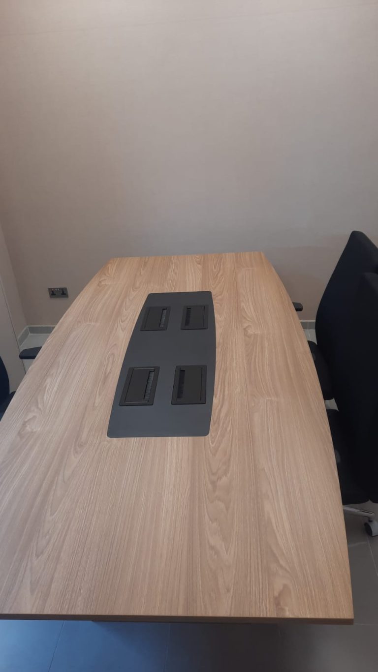 Hospital meeting room conference table with integrated cable management ports and task chairs