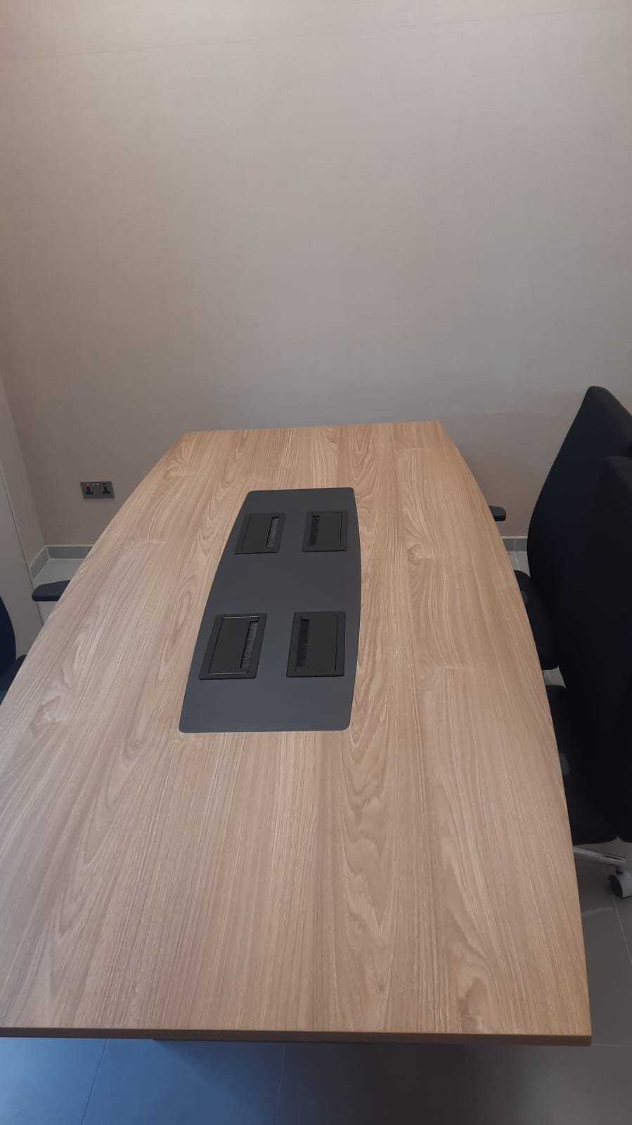 Hospital meeting room conference table with integrated cable management ports and task chairs